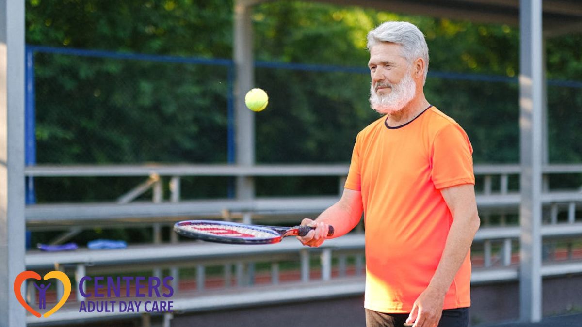 An elderly man playing tennis outdoors in the afternoon, dressed in a sports shirt.