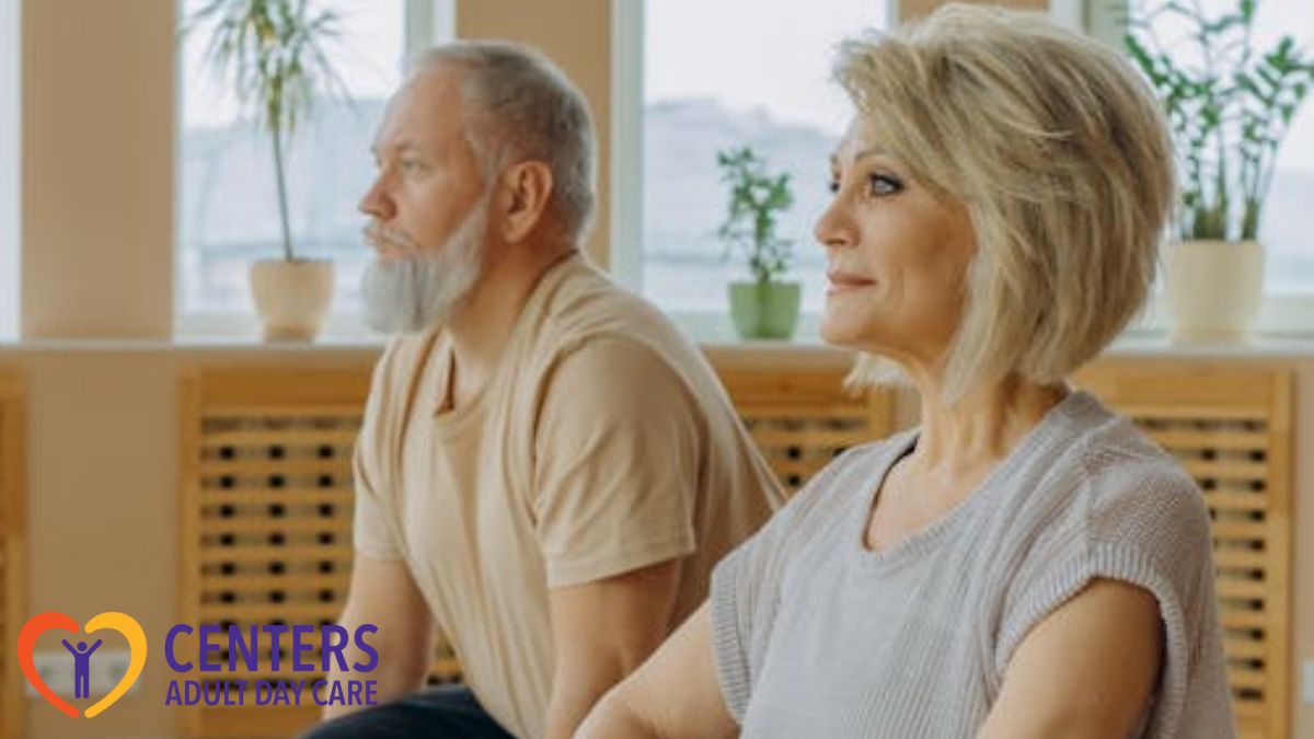 A senior man and woman practicing yoga together at a day care center studio.