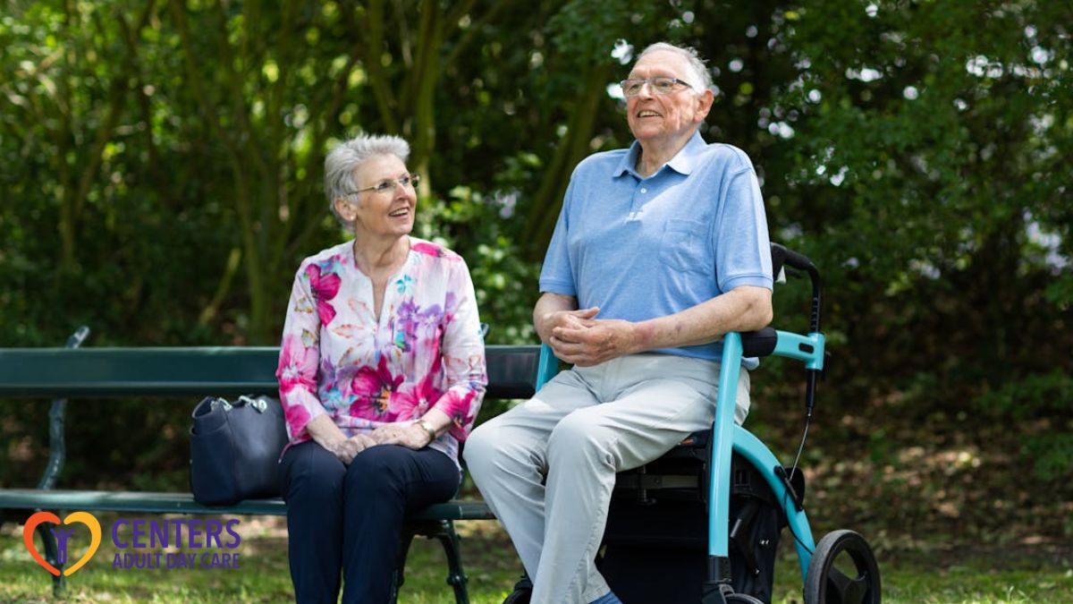 Two seniors enjoying the sunshine at a park during an adult day care outing in Richmond.