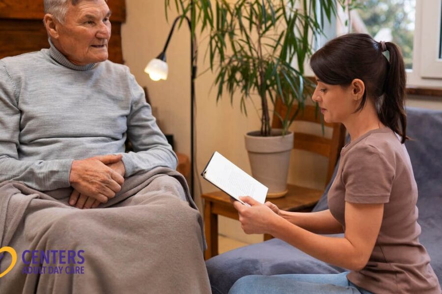 A carer reads to an elderly person.