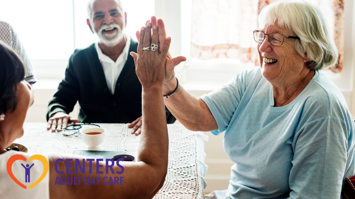 A senior gives another senior a high five while enjoying a day of bonding and activities, symbolizing friendship and joyful engagement in adult day care.