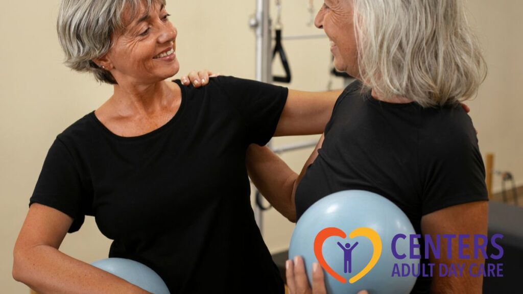 Two senior women share warm greetings, gently touching each other’s shoulders in a physical fitness center during physical therapy.