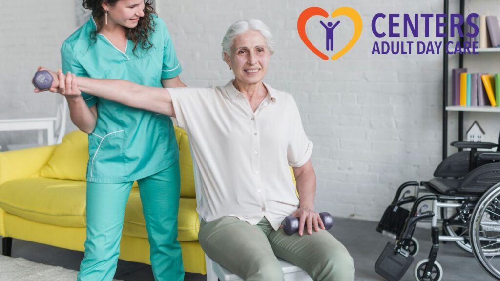 A senior woman seated in a chair stretches her arm to the side while lifting a handheld weight, guided by her female therapist during physical therapy.
